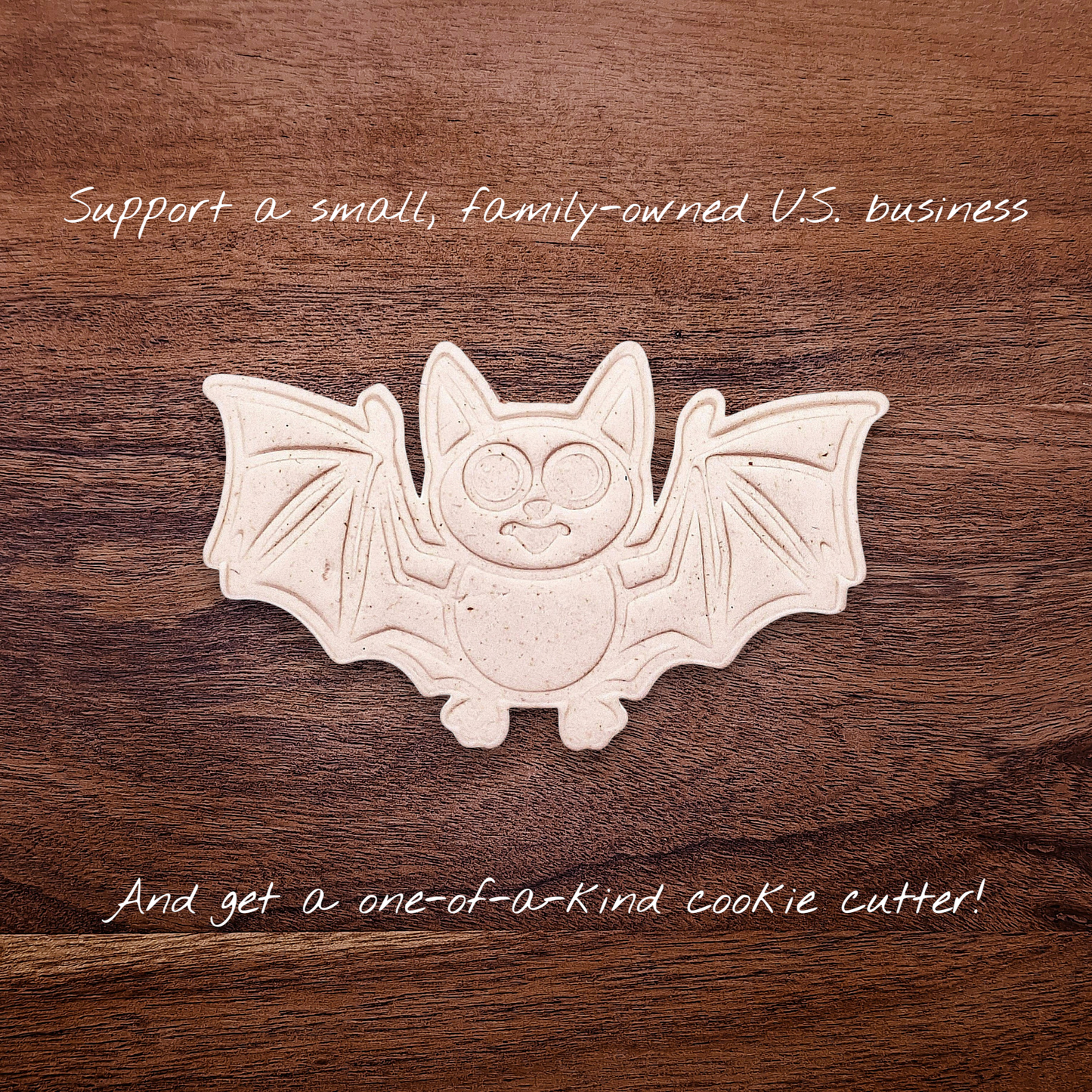 Dough cutout with bat design pressed by cutter and stamp set, showing detailed lines—great for easy Halloween cookie decorating without icing.