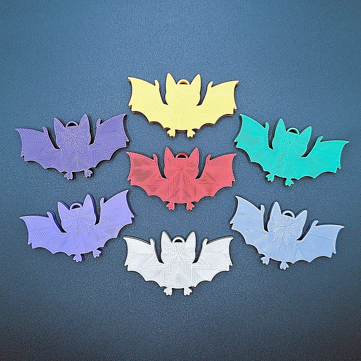 Front view of multicolor bat keychains, sustainable Halloween key rings, gothic party favors, and quirky bat-themed accessories.