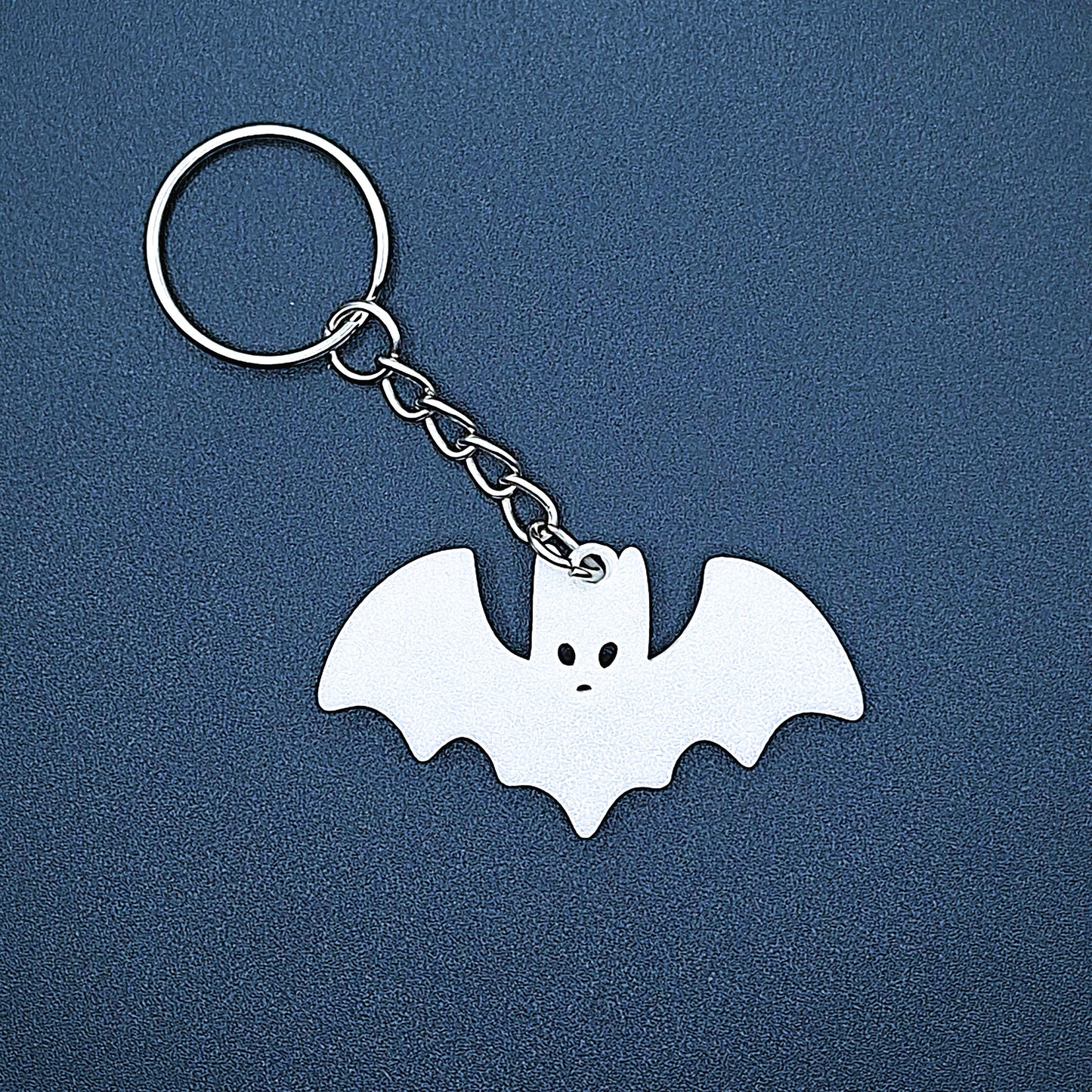 White bat keychain—bold, creepy-cute charm handmade from plant-based plastic; great for vampire fans, goth gifts, or Halloween keyrings.