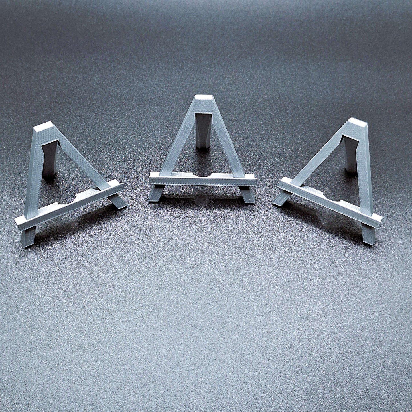 Mini foldable easels in silver – sleek and portable display stands ideal for showcasing artwork, signs, photos, or merchandise at craft fairs, shops, and events.