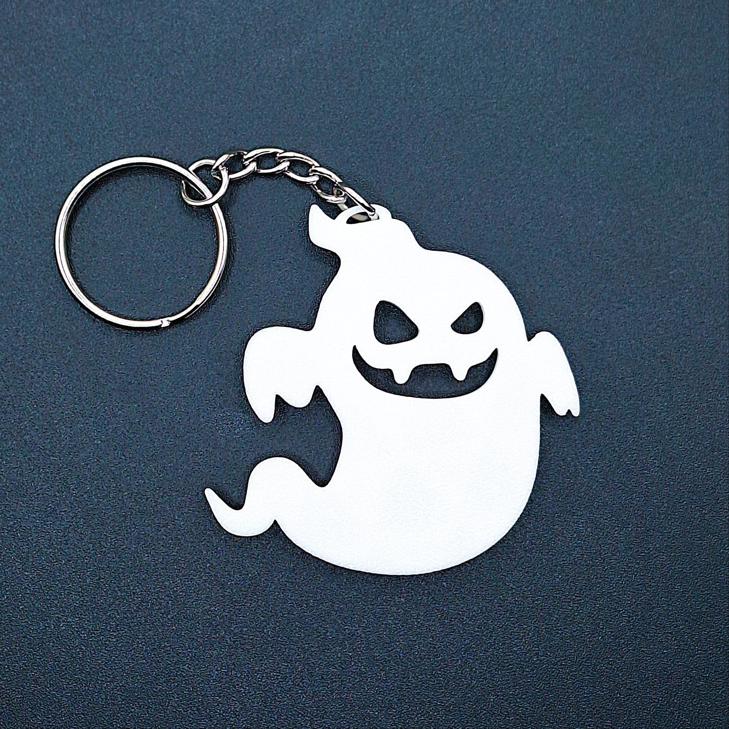 Front of white ghost keychain with a smiling face, lightweight and eco-conscious, great for October gifting, spooky aesthetics, or key ring collectibles.