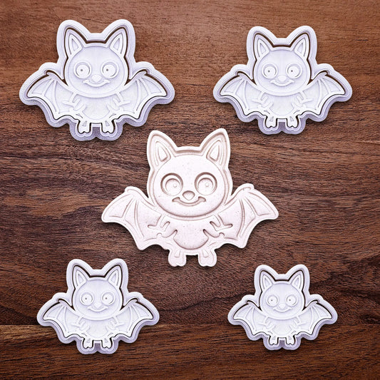 Close-up of bat cookie cutters with matching stamps, perfect for spooky Halloween cookies, fondant crafts, and gothic-themed baking projects.