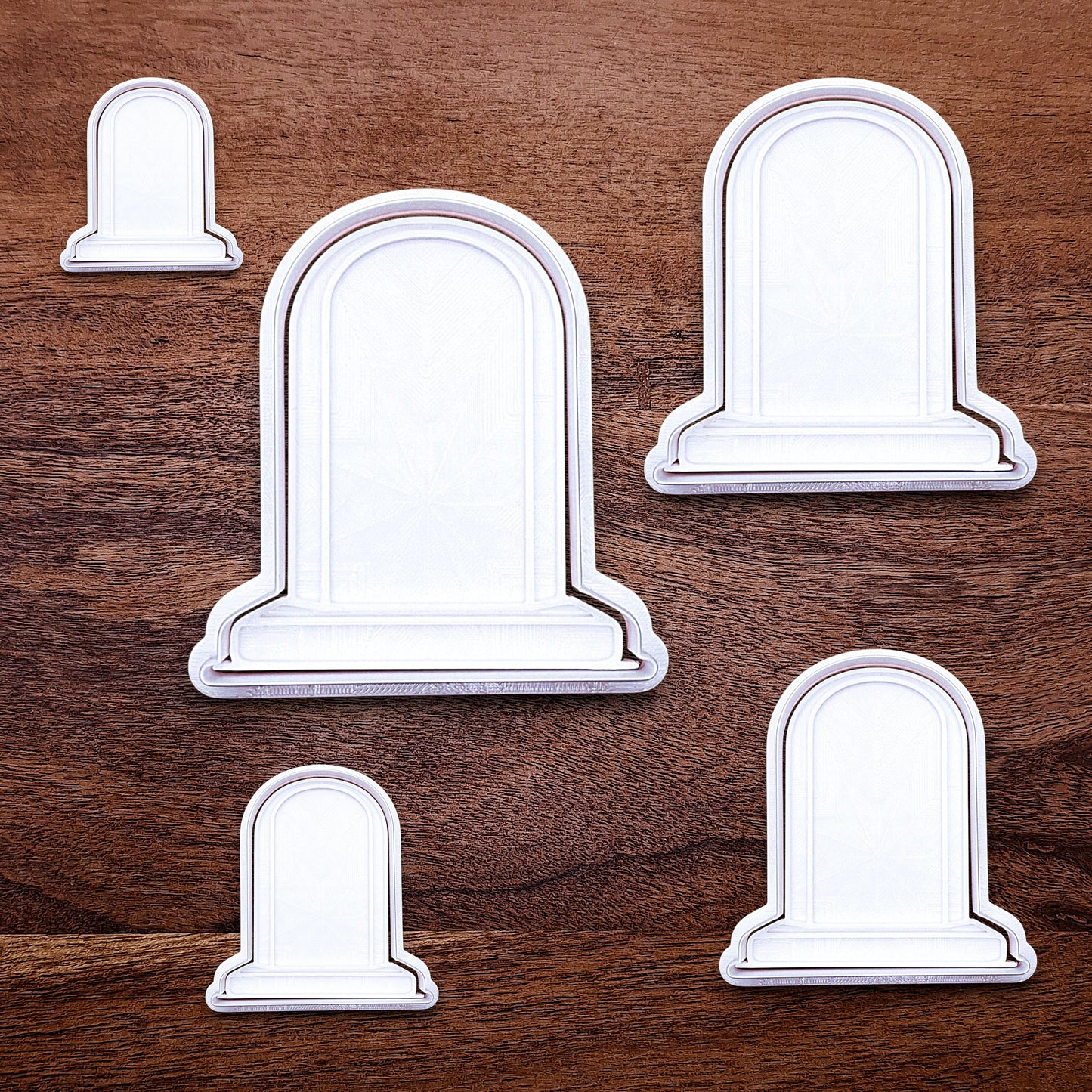 Multiple gravestone cookie cutters with stamps for Halloween treats and spooky desserts, adds detail to dough, fondant, and craft projects.