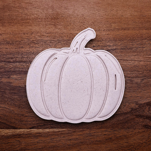 Pumpkin-shaped dough cutouts made with cutter and stamp. Shows detailed lines and clean shapes—ideal for autumn cookies or pie crust toppers.