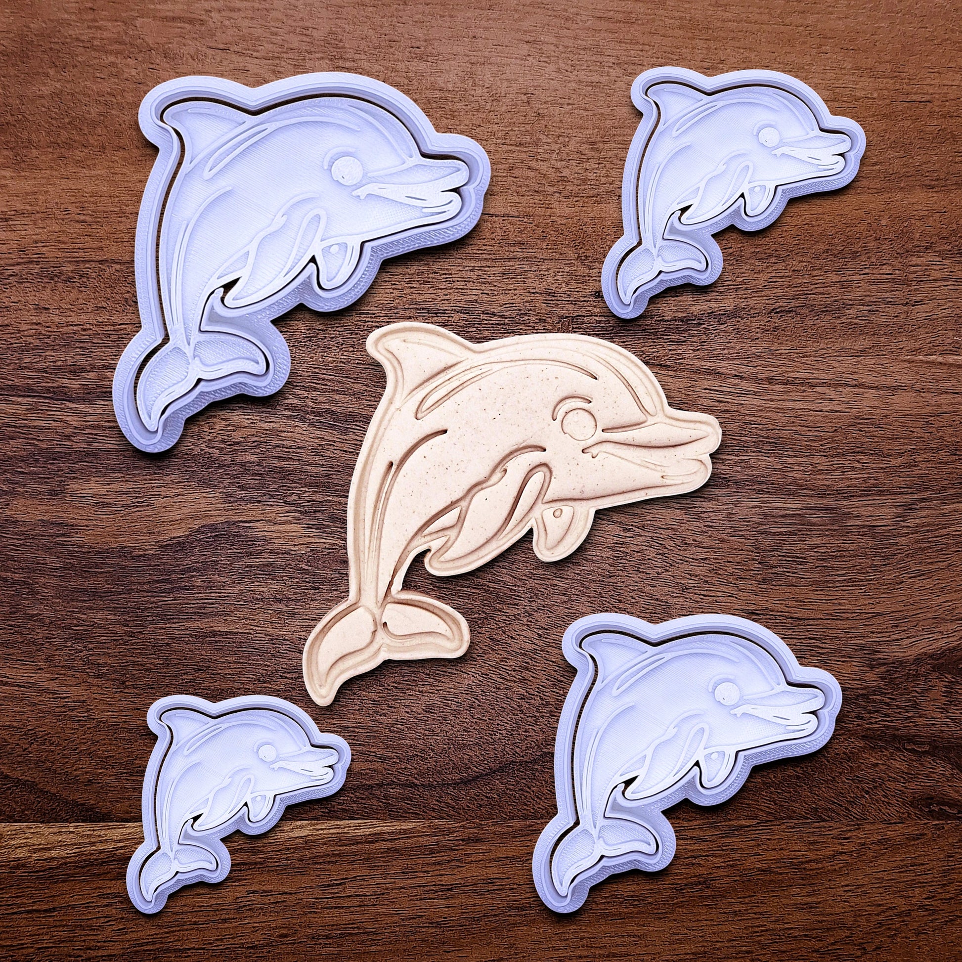 Handmade and customizable dolphin cookie cutter stamp set in multiple sizes alongside a dough imprint, perfect for ocean-themed cookies, birthdays, aquatic fondant toppers, and sea animal baking projects.