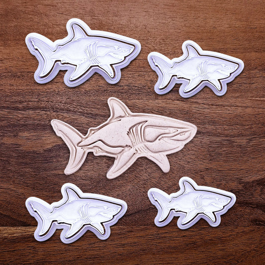 Handmade and customizable shark cookie cutter and stamps alongside a dough cutout and imprint, great for beach themed baking, fondant crafts, or ocean-themed cookies.