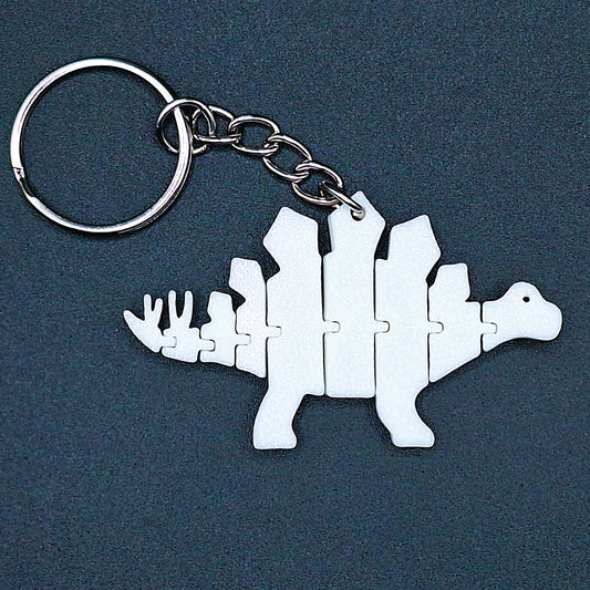 White dino fidget keychain with jointed body and tail, shown with attached keyring, perfect as a sensory gift or fun eco toy for all ages.