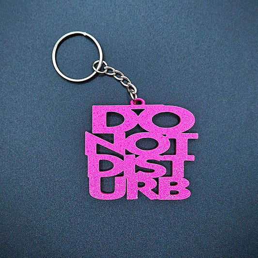 Pink Do Not Disturb keychain in bold lettering, handmade from PLA plastic, ideal for fun desk accessories or self-care boundary gifts.