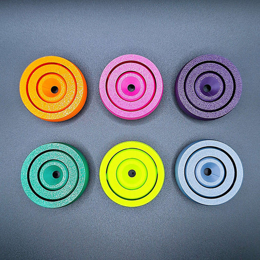 Top-down view of six smooth-surfaced fidget spinners in assorted colors, great for tactile calming, fidgeting, and mental focus.