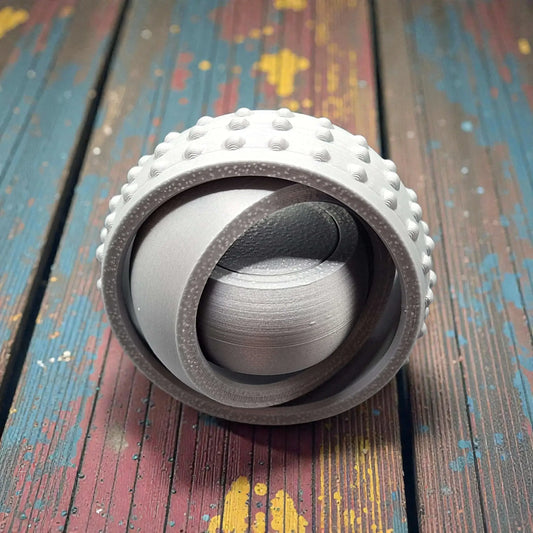 Front view of silver pocket-sized fidget spinner, minimal and modern design made from plant-based plastic for portable stress relief.