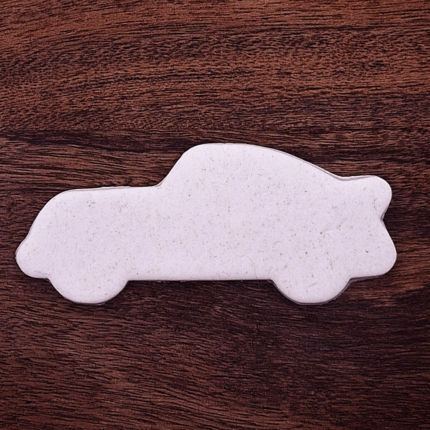Racecar cookie dough cutout with detailed stamped design. Perfect for racing-themed birthday treats, car cookies, or fun fondant decorations.