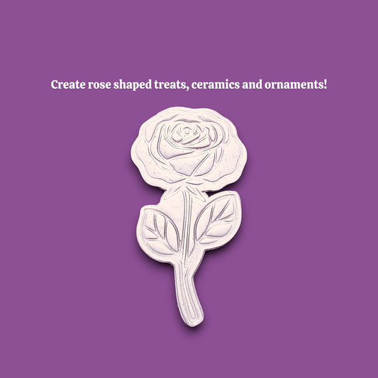 A white rose-shaped cookie cutter dough cutout and imprint is centered on a solid purple background, with white text above reading 'Create rose shaped treats, ceramics and ornaments!'.