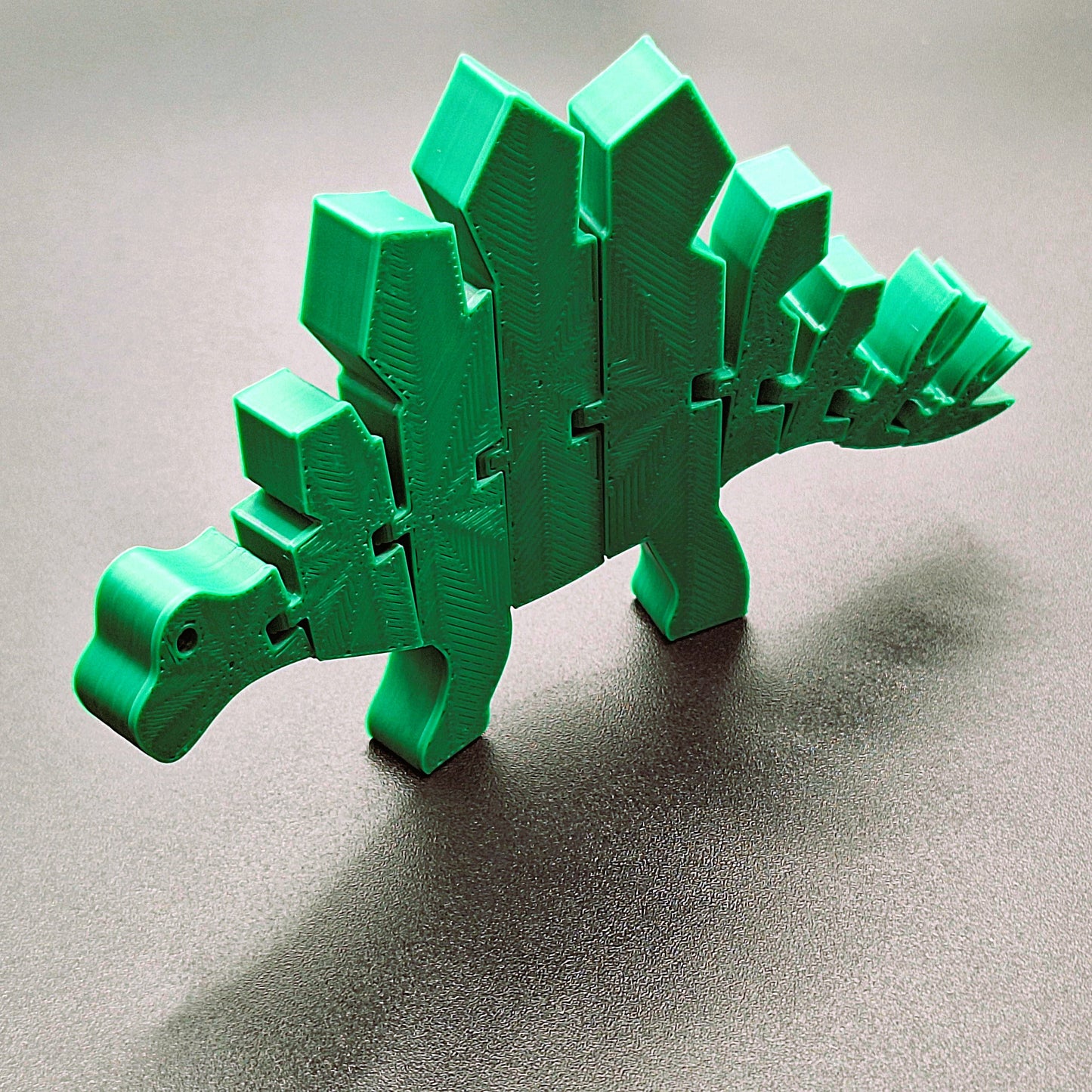 Fun articulated stegosaurus fidget figure for dino fans, designed for sensory play, stress relief, party favors, and creative gifts.