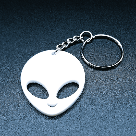 Cute alien keychain with classic UFO-style head and big eyes, front-facing, shown in vibrant white color with keyring.