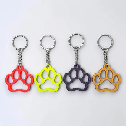Handmade and customizable paw keychains in four colors, ideal for honoring pets, gifting to animal lovers, or everyday use.