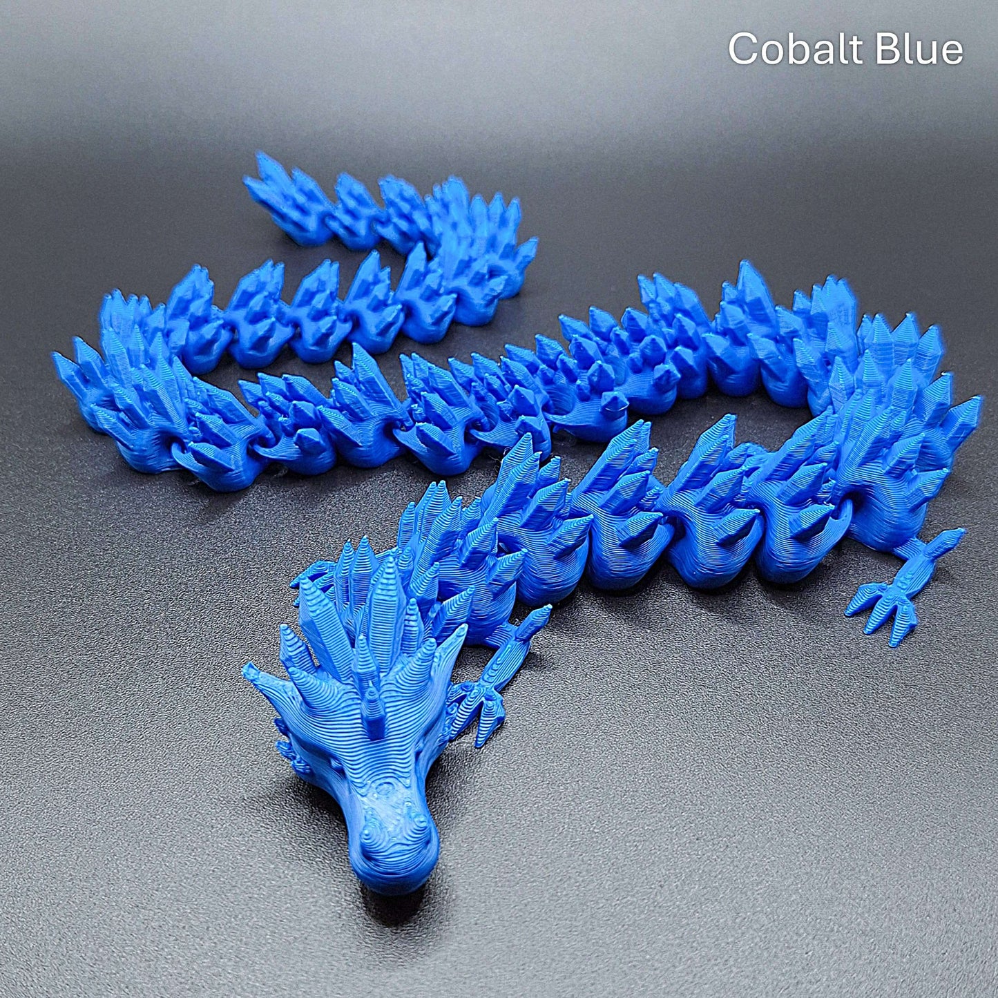 Cobalt blue articulated dragon fidget toy with segmented poseable body, handmade in eco-friendly PLA