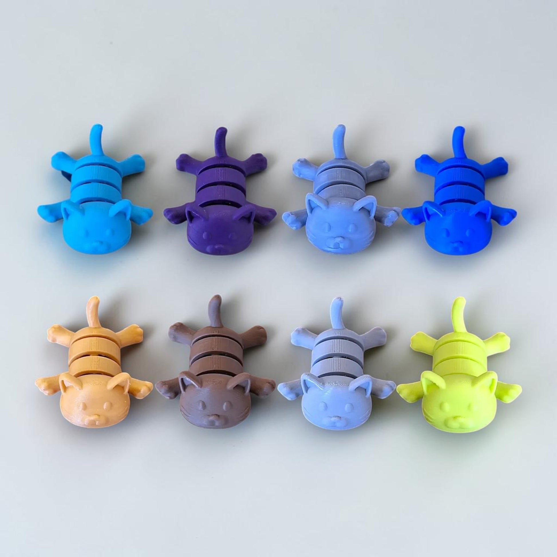 Customizable articulated cat keychains in assorted colors, great for keys, backpacks, and small gifts with charm.