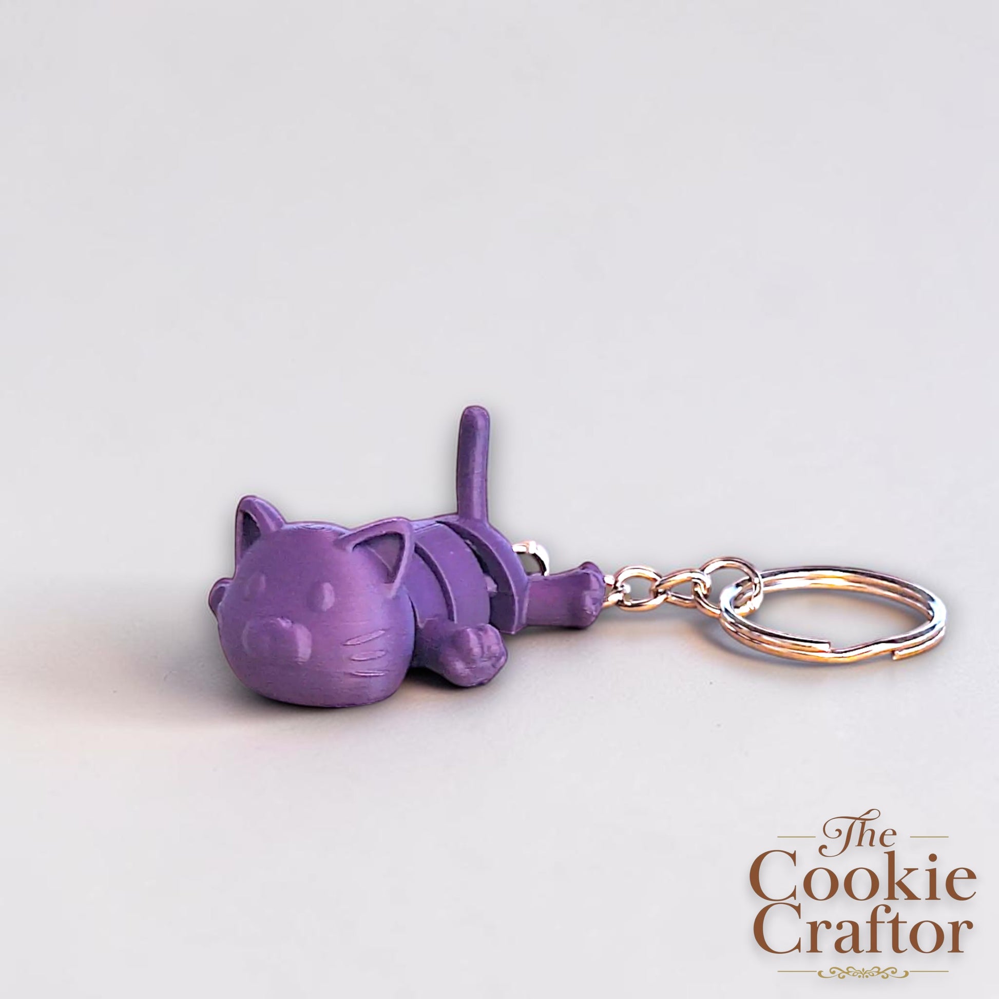 Handmade and customizable articulated cat keychain in indigo purple, great for keys, backpacks, and small gifts with charm.