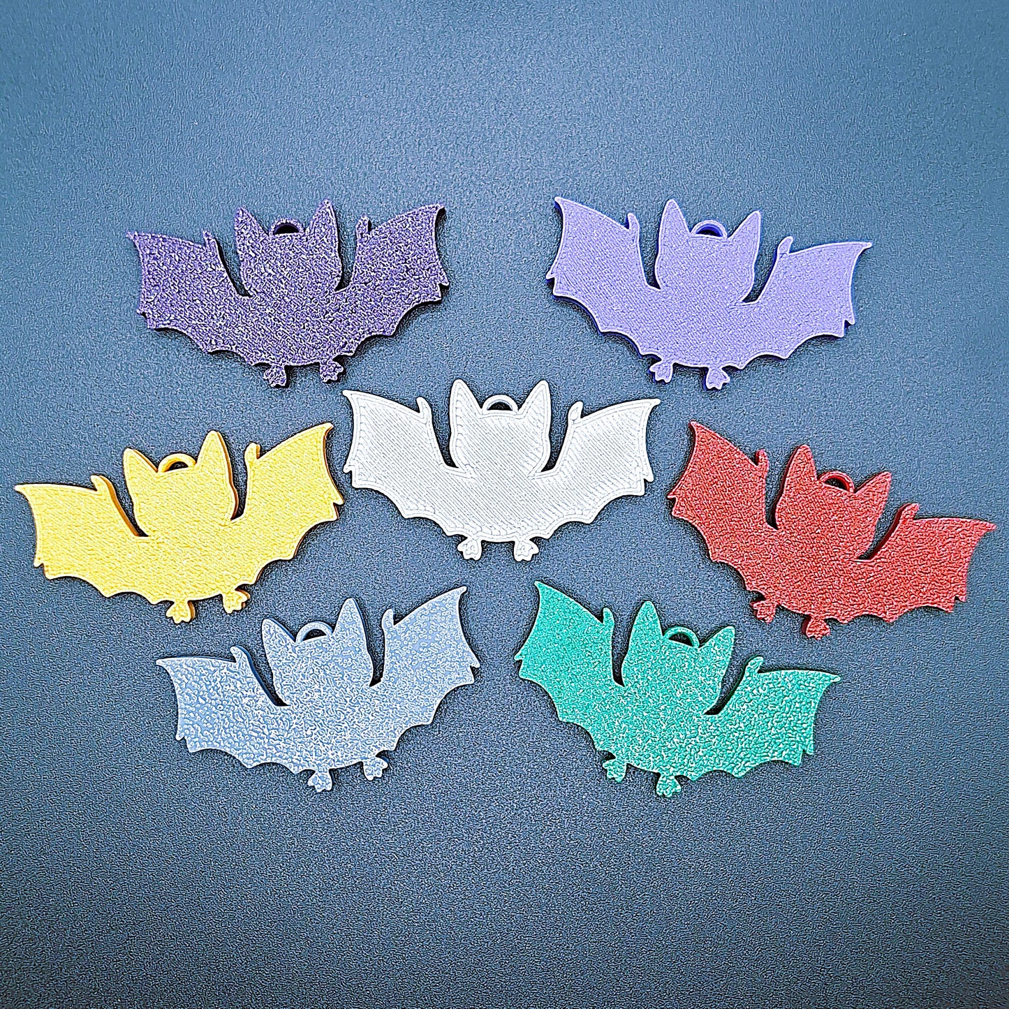 Front view of multicolor bat keychains, sustainable Halloween key rings, gothic party favors, and quirky bat-themed accessories.