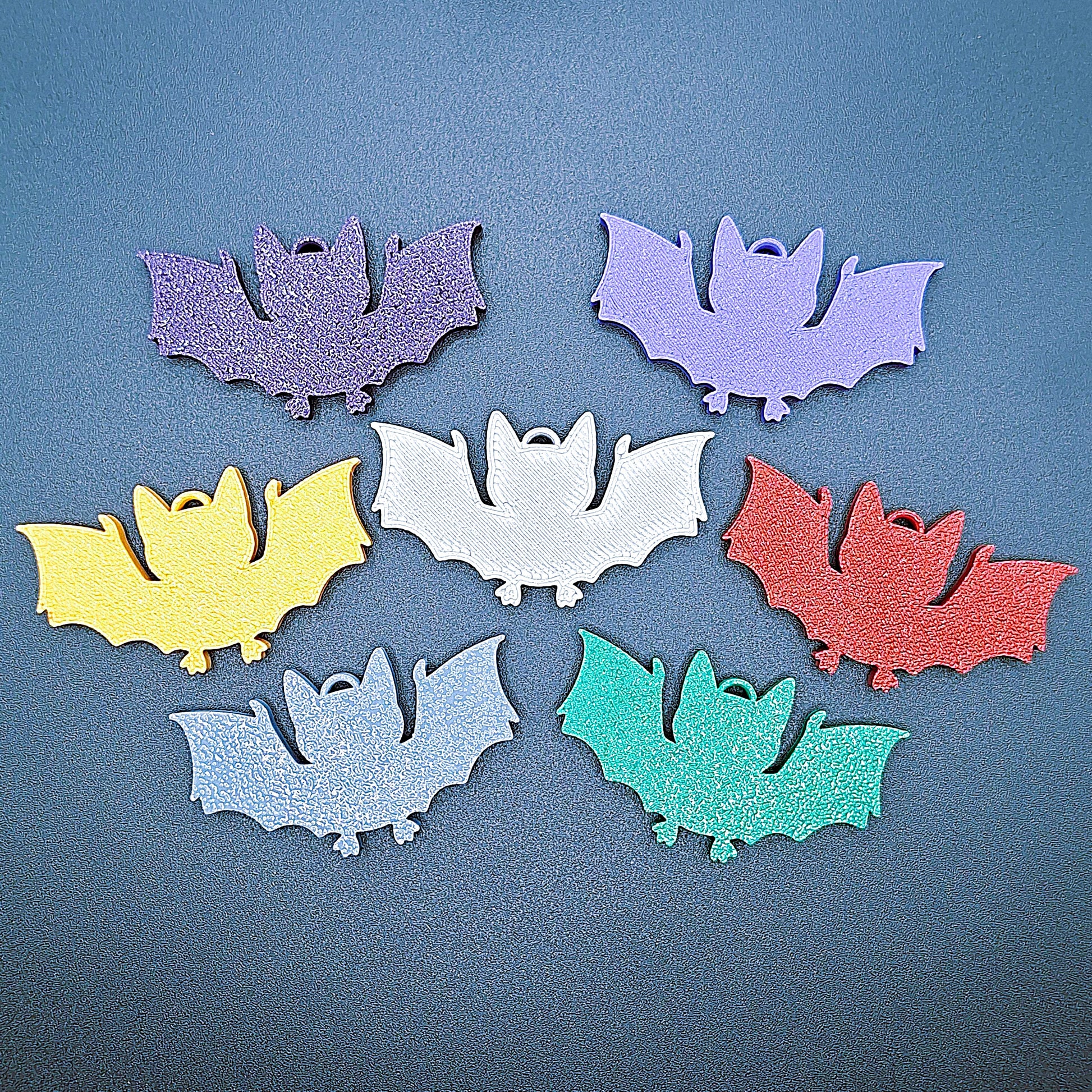 Front view of multicolor bat keychains, sustainable Halloween key rings, gothic party favors, and quirky bat-themed accessories.