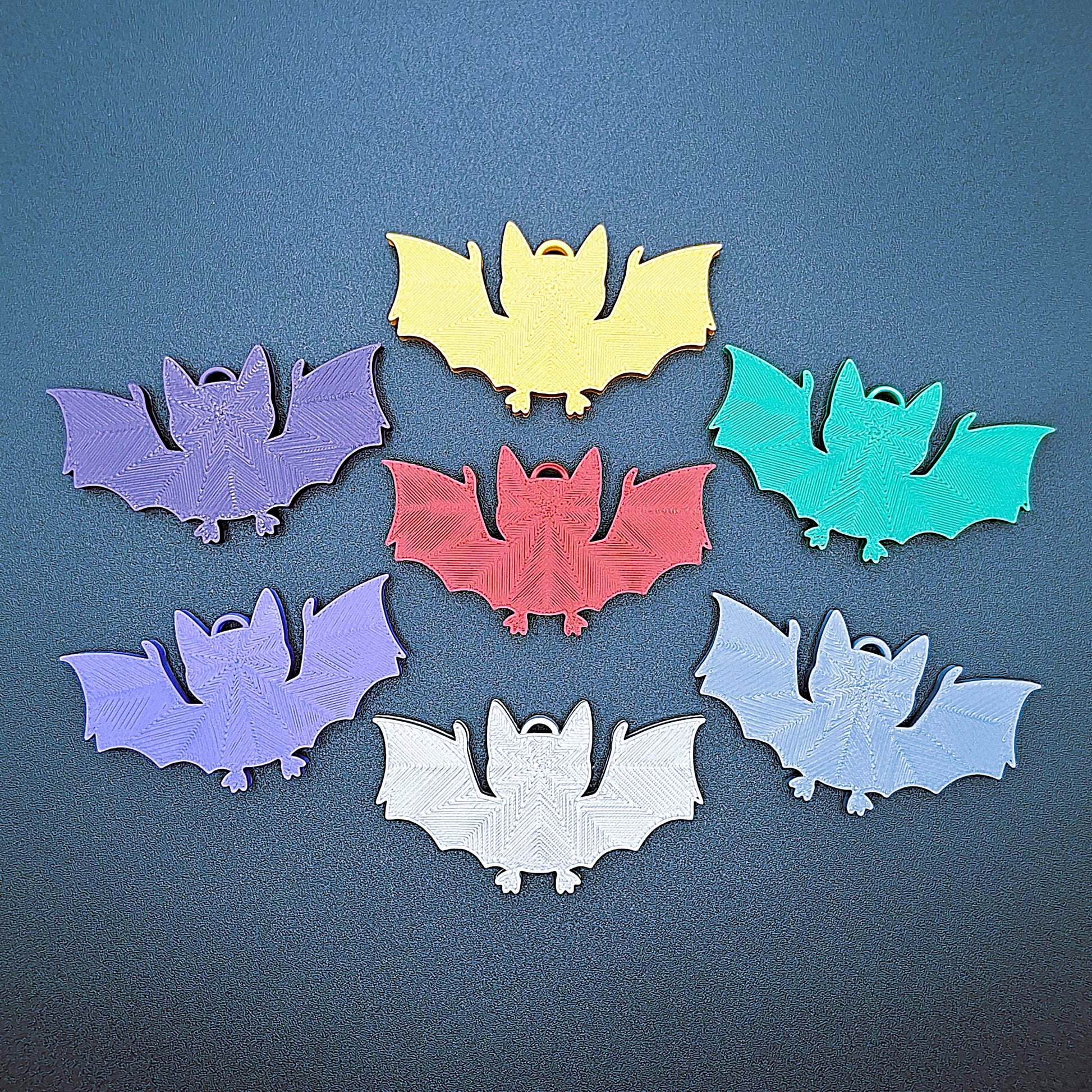 Front view of multicolor bat keychains, sustainable Halloween key rings, gothic party favors, and quirky bat-themed accessories.