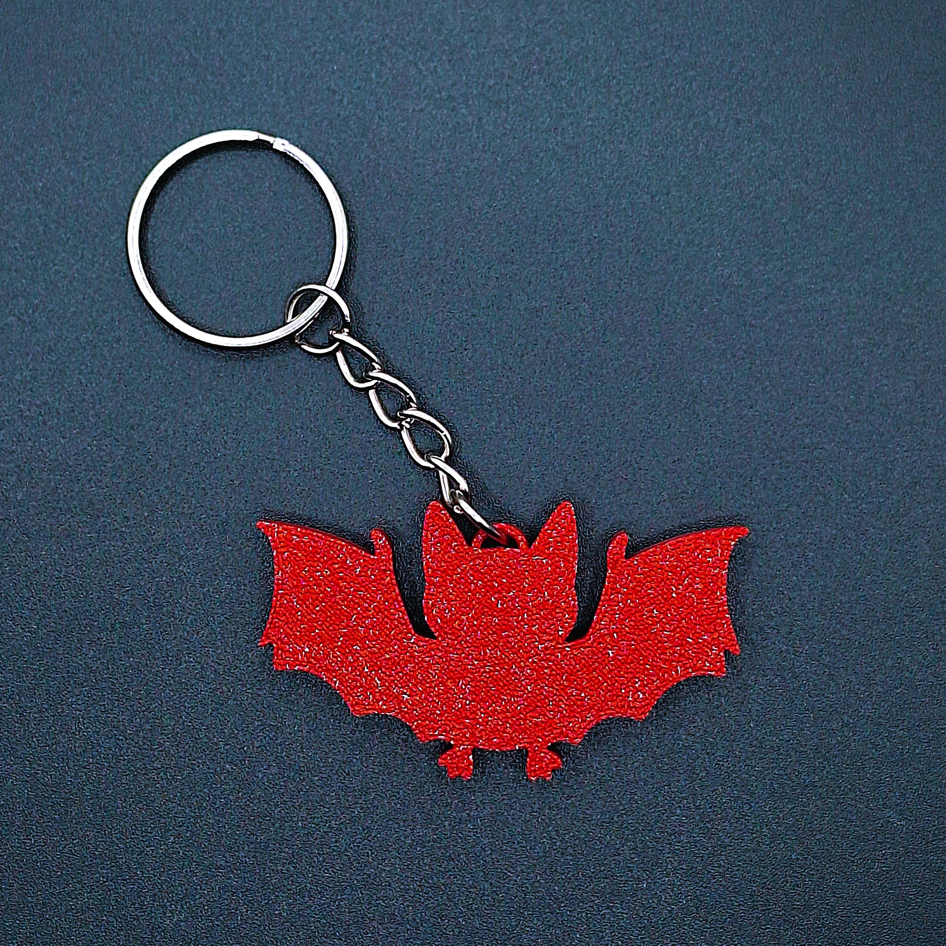 Front view of red bat keychain, handmade eco-friendly Halloween key ring, spooky gothic bag charm, and vampire-themed gift accessory.