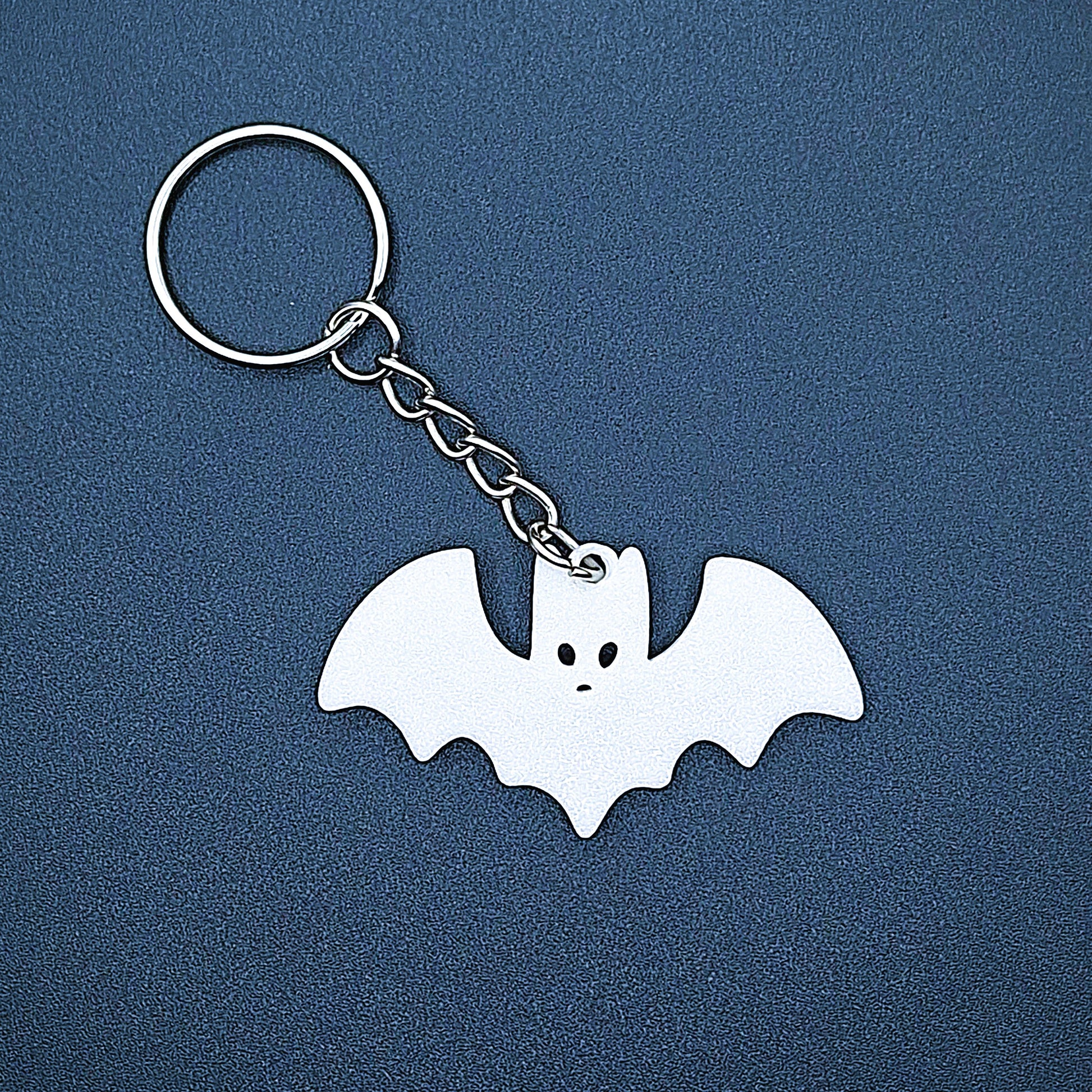 White bat keychain—bold, creepy-cute charm handmade from plant-based plastic; great for vampire fans, goth gifts, or Halloween keyrings.