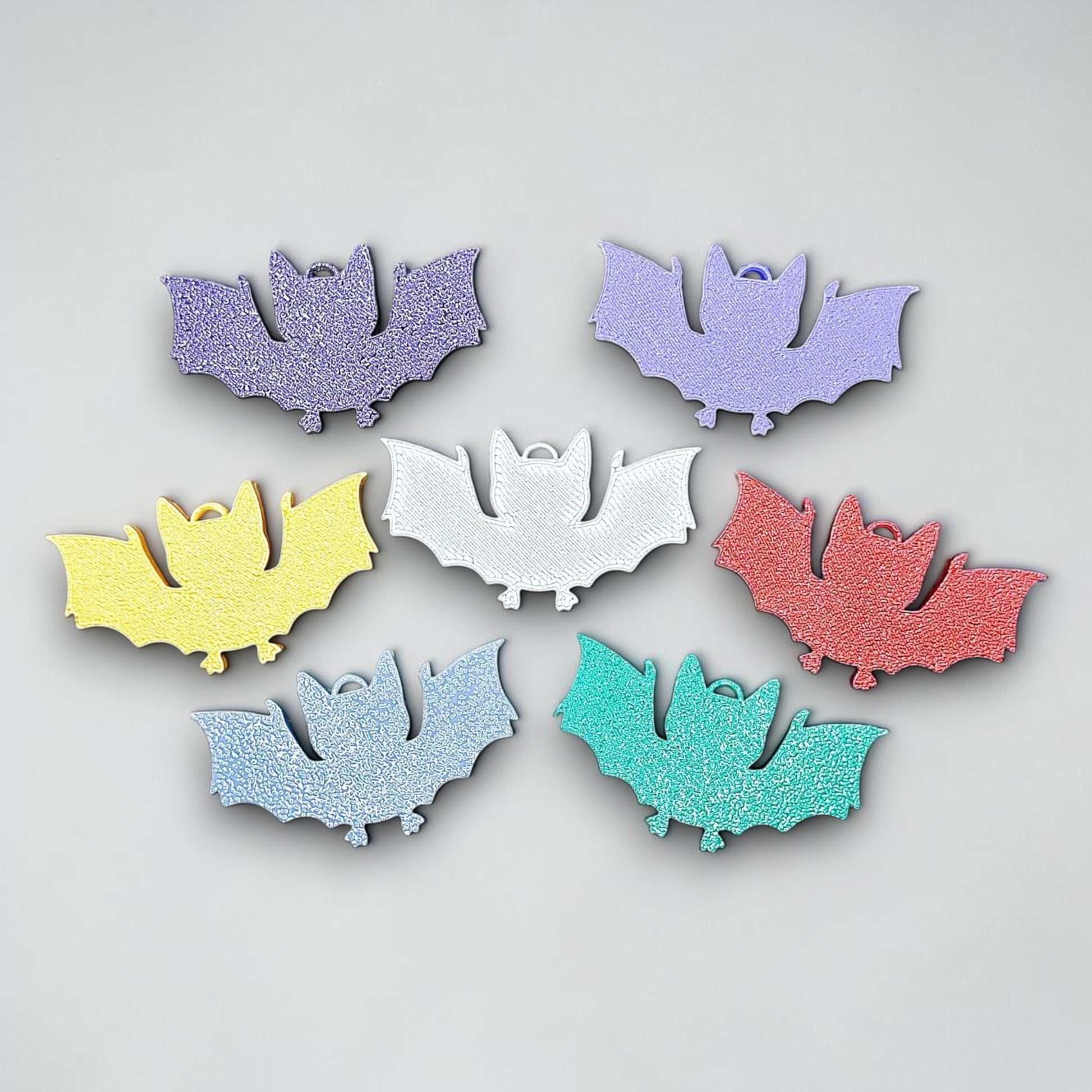 Customizable bat keychains in assorted colors, perfect for Halloween trick or treats, gothic party favors, and bat-themed accessories.