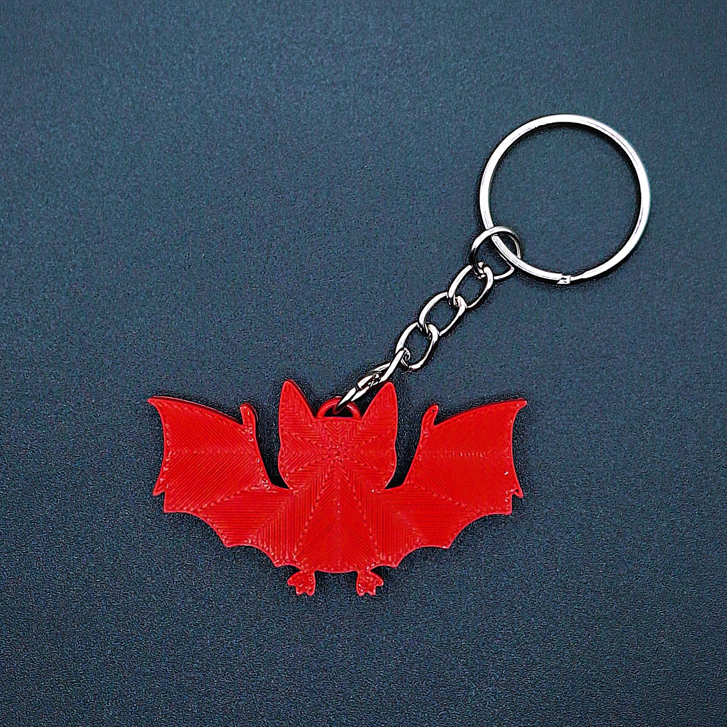 Reverse side of red bat keychain, lightweight sustainable Halloween key ring, quirky gothic charm, and fun vampire-themed gift.