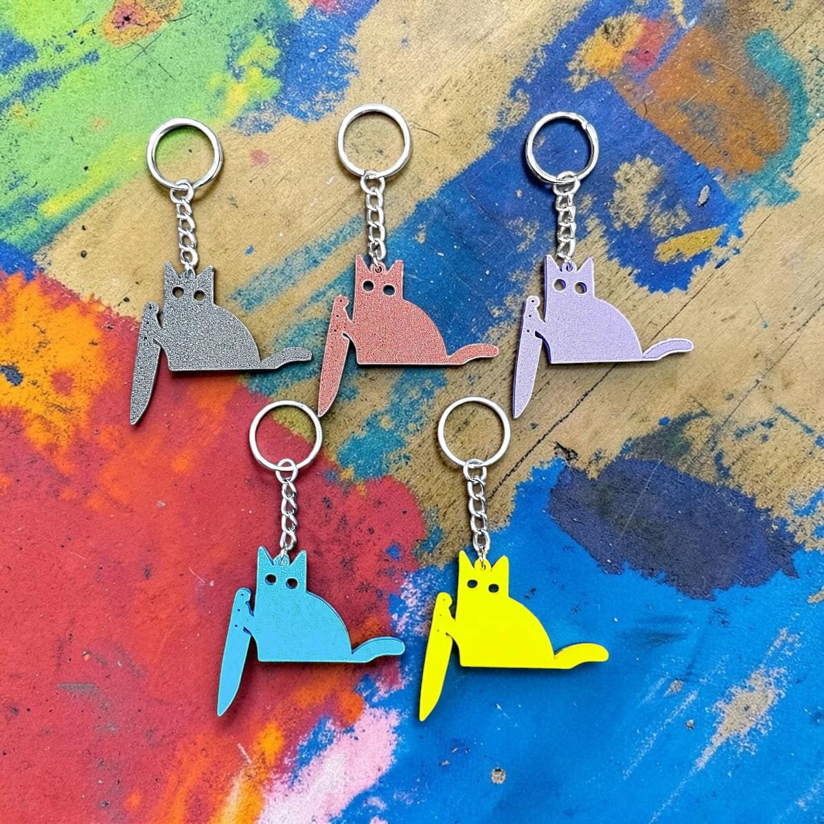 Five handmade and customizable black cat keychains in assorted colors, great for creepy cute key rings, trick or treat gifts, and Halloween parties.