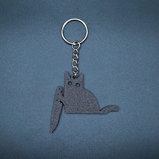 Front view of black cat keychain holding a kitchen knife, made from eco-friendly PLA, perfect for spooky gift giving or gothic cat lovers.