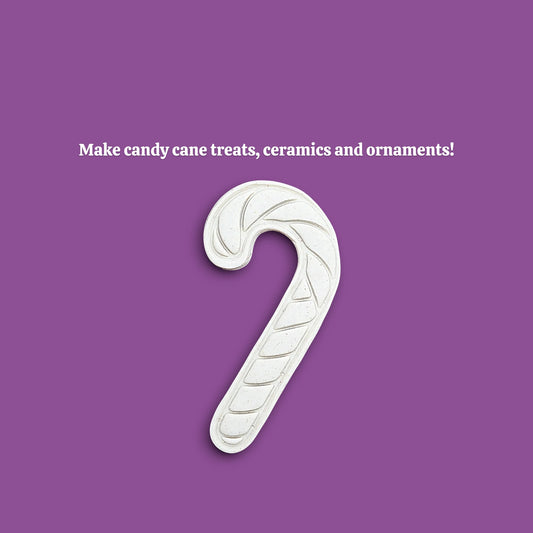 A white candy cane-shaped cookie cutter mold is centered on a solid purple background, with the text 'Make candy cane treats, ceramics and ornaments!' above it.