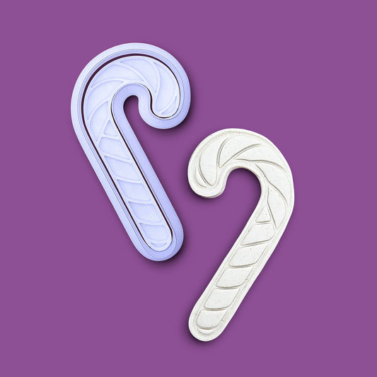 Candy cane cookie cutter and stamp alongside a dough cutout and imprint, perfect for holiday treats, gifting and ceramics.