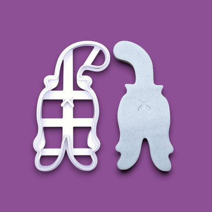 Cat butt cookie cutter shown alongside a dough cutout and imprint, perfect for gag gifts, holiday treats and ceramics. Handmade and customizable in 30 unique colors.