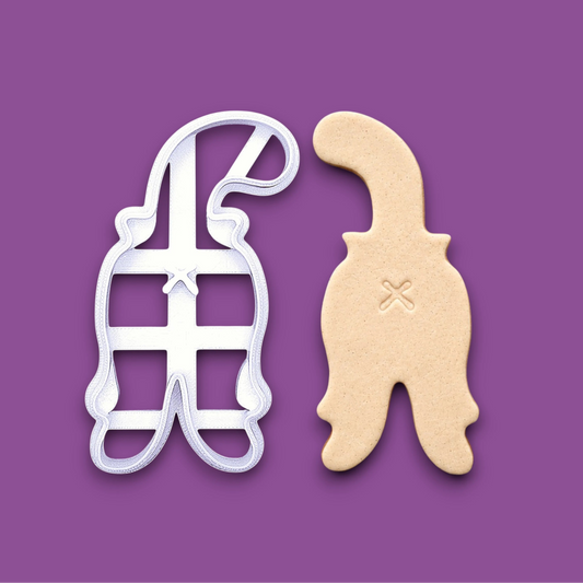 Cat butt cookie cutter shown alongside a dough cutout and imprint, perfect for gag gifts, holiday treats and ceramics. Handmade and customizable in 30 unique colors.