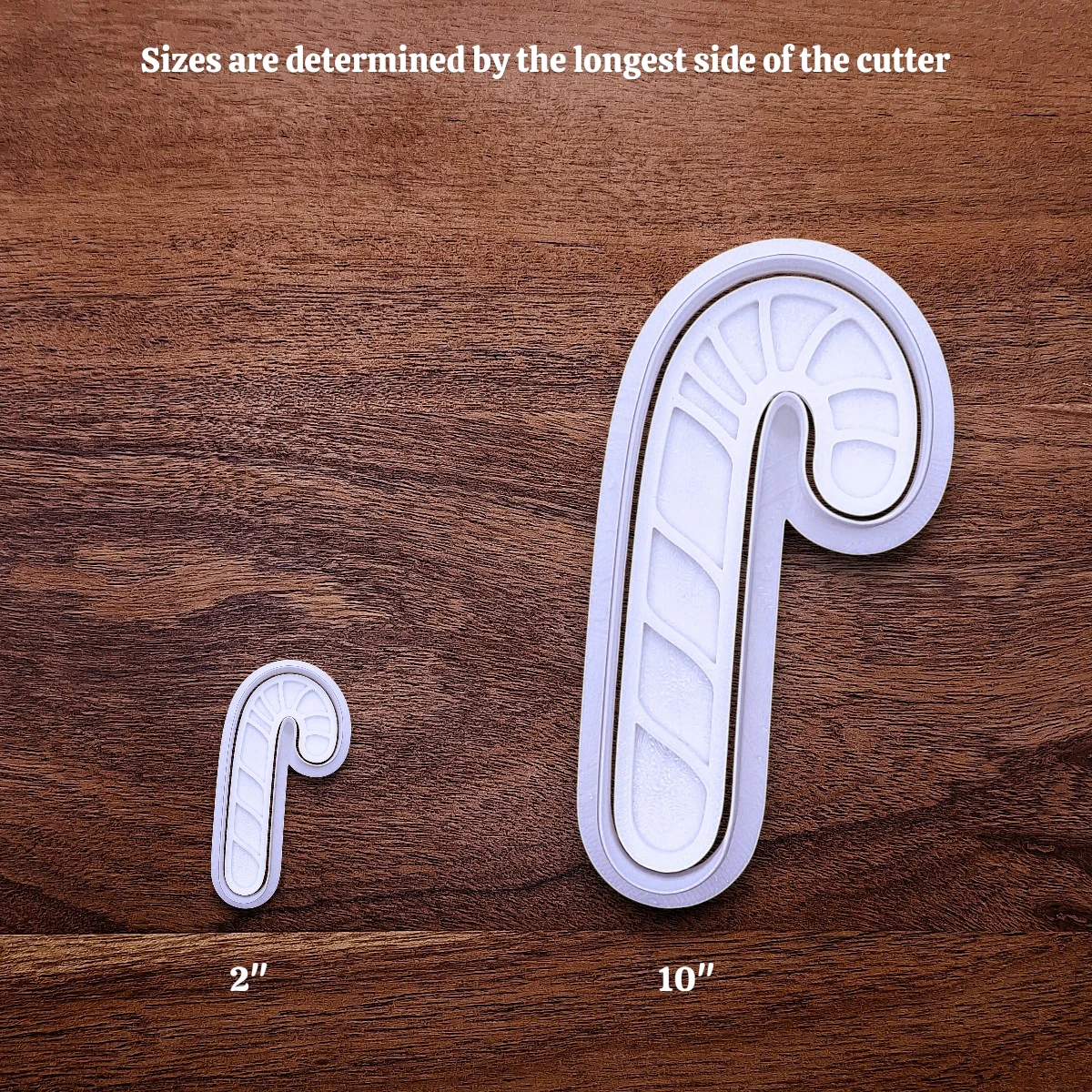 Two candy cane cookie cutters and stamps shown side by side with an infographic showing how increasing the size works.