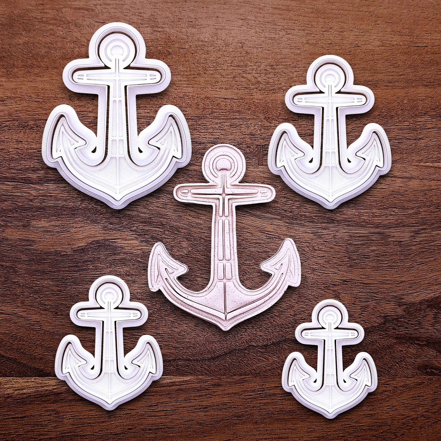 View of multiple anchor cookie cutters with matching stamps. Ideal for making detailed cookies, fondant toppers, or ocean party treats.