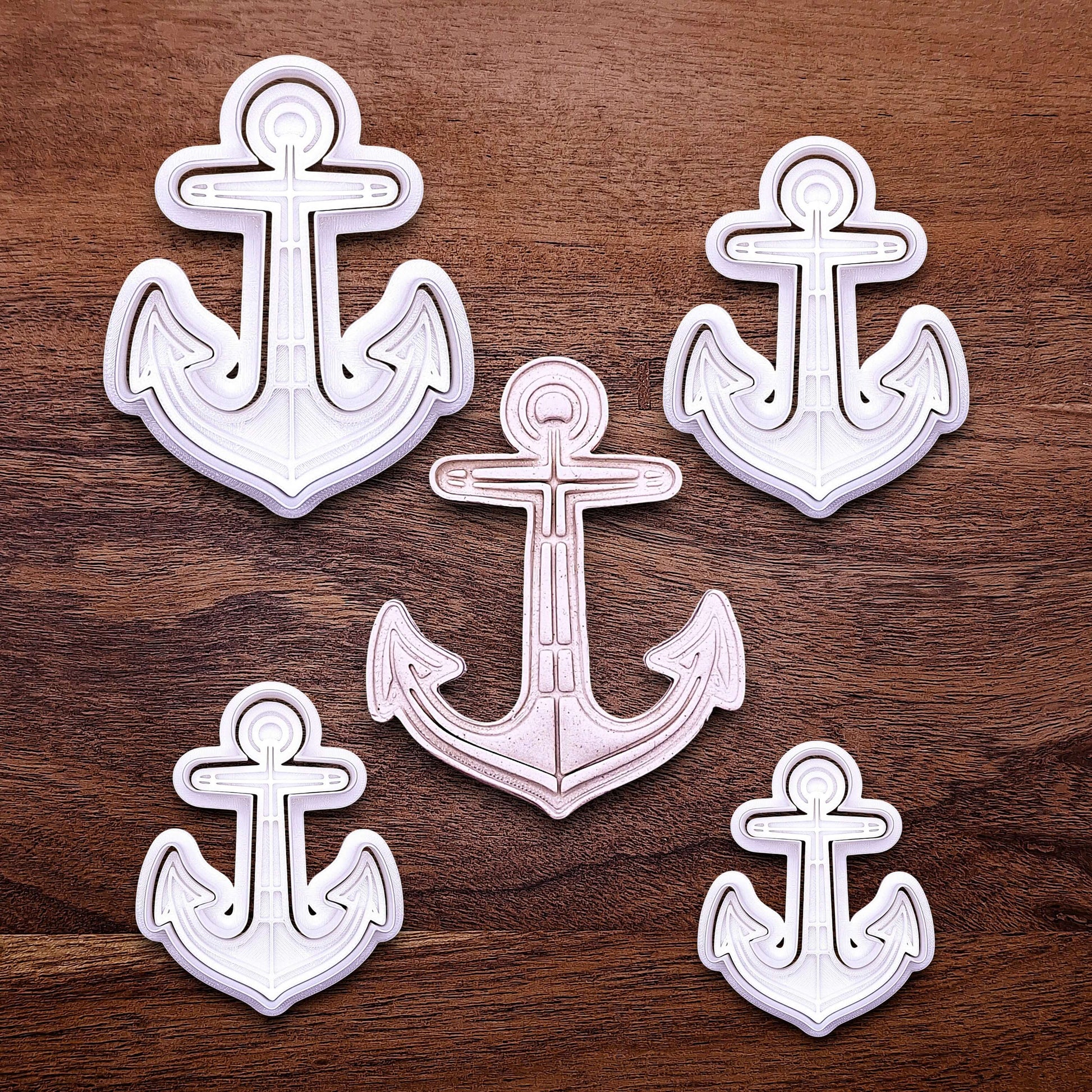 View of multiple anchor cookie cutters with matching stamps. Ideal for making detailed cookies, fondant toppers, or ocean party treats.
