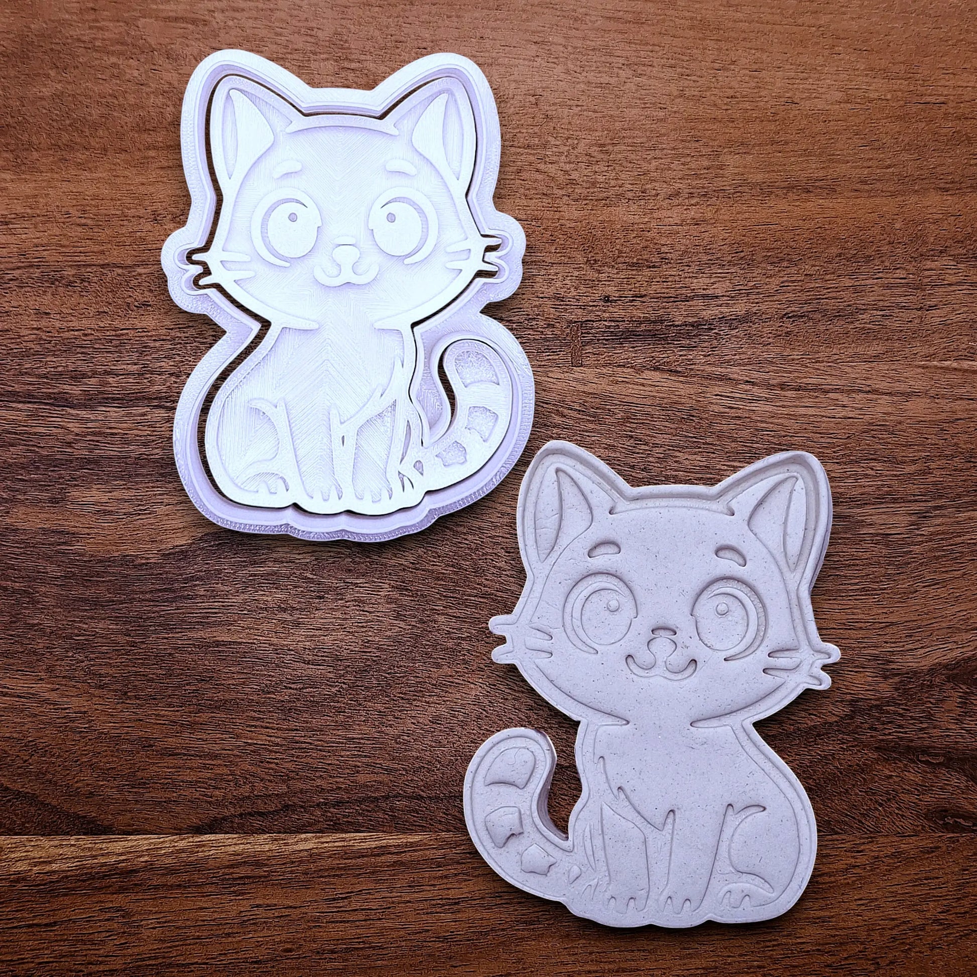 Customizable cat cookie cutter and stamp alongside a cat dough cutout and imprint, perfect for kitty cookie designs, fondant toppers, birthday parties, crafts or cat themed baking projects.
