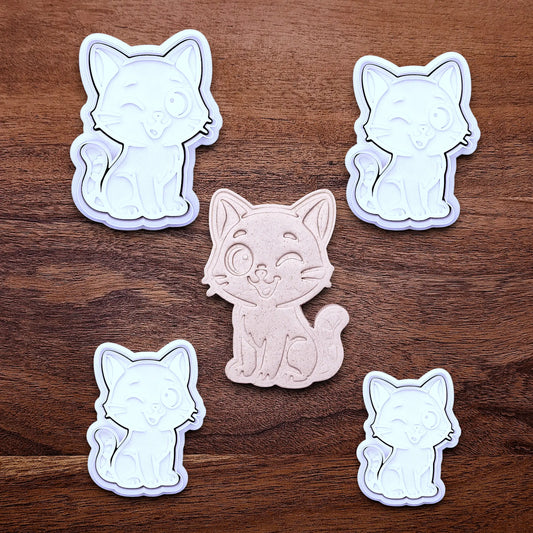 Winking cat cookie cutters and stamps in multiple sizes alongside a dough cutout and imprint, great for creating detailed, cat-themed cookies, fondant pieces, or party treats for birthdays, parties and craft projects.