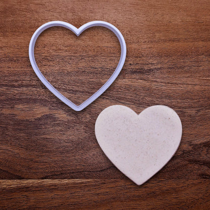 Handmade and customizable heart cookie cutter alongside a dough cutout, perfect for Valentine's Day baking, sweet treats and party favor creations.