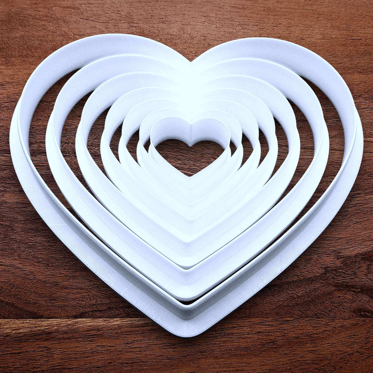Customizable 7-piece heart cookie cutter set with sizes 5”–1.4”. Perfect for layered cookies, fondant, crafts, weddings, and Valentine’s Day baking fun.