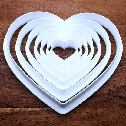 Customizable 7-piece heart cookie cutter set with sizes 5”–1.4”. Perfect for layered cookies, fondant, crafts, weddings, and Valentine’s Day baking fun.
