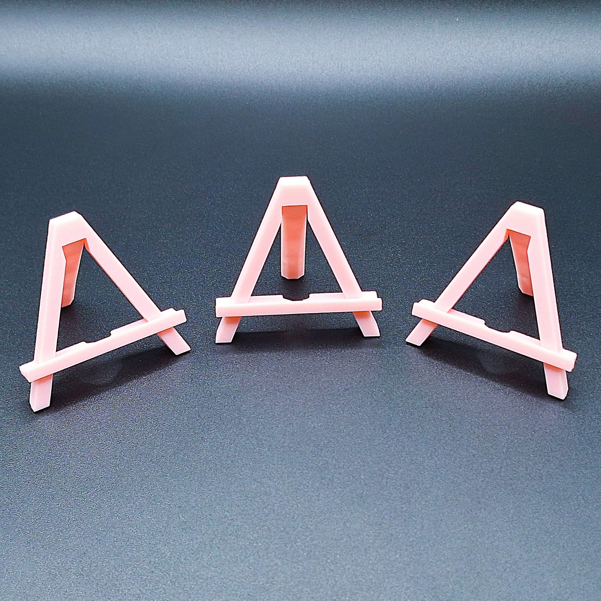 Mini foldable easels in pink – sleek and portable display stands ideal for showcasing coins, trading cards, artwork, signs, photos, or merchandise at craft fairs, shops, and events.