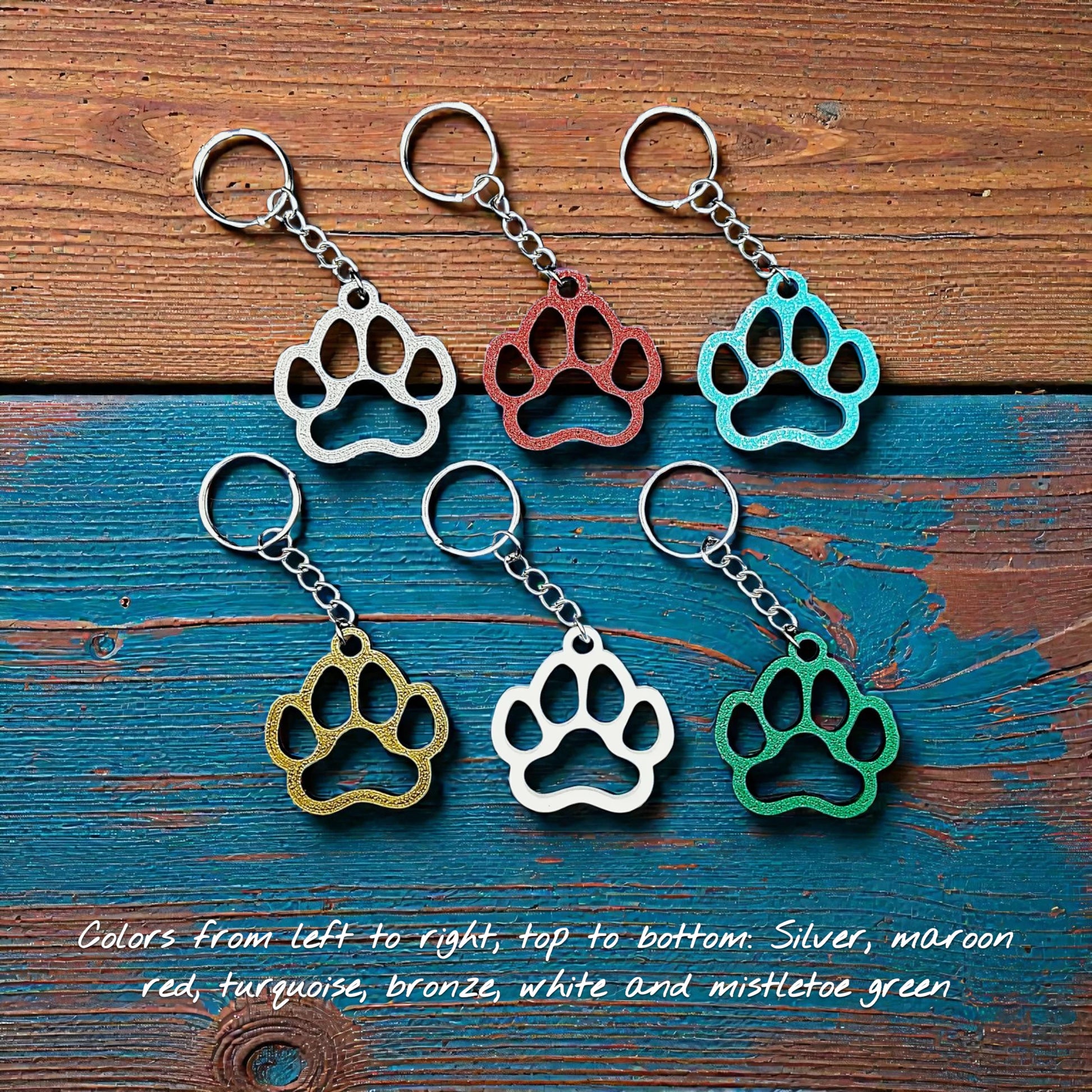 Six paw print keychains in assorted colors, made from biodegradable PLA plastic, perfect for dog moms, cat lovers, or rescue volunteers.