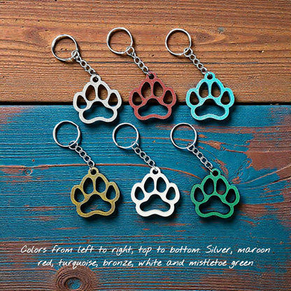 Six paw print keychains in assorted colors, made from biodegradable PLA plastic, perfect for dog moms, cat lovers, or rescue volunteers.