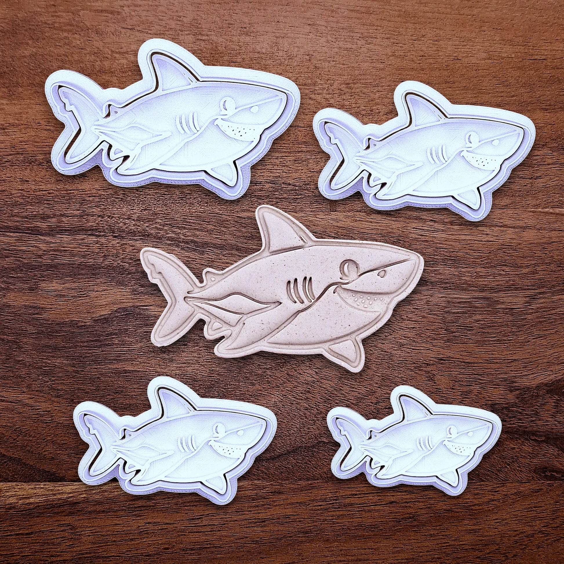 Multiple customizable ocean shark cookie cutters and stamps, creates standout ocean cookies with charming face and fin details, perfect for themed birthdays, baby showers, and beach parties.