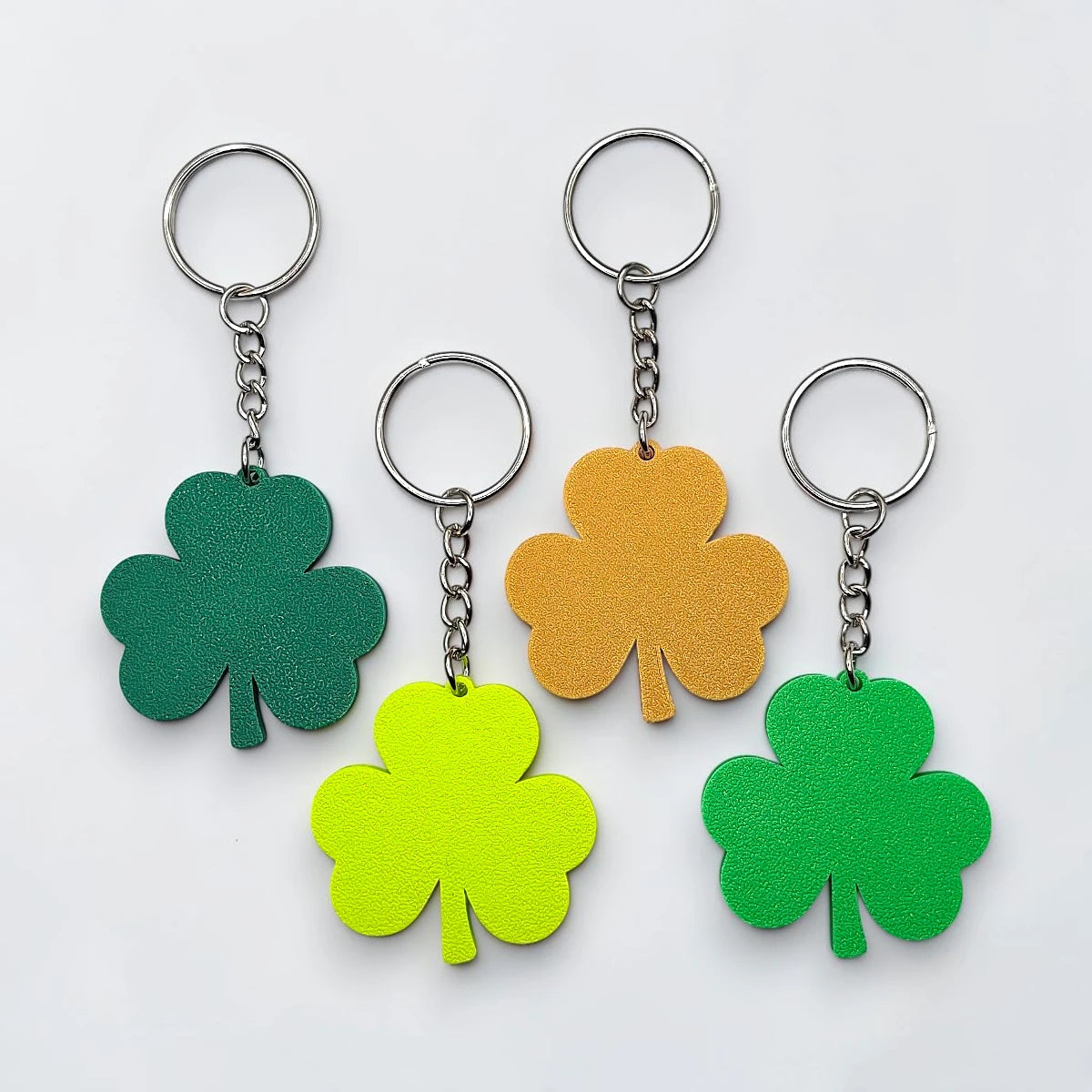 Handmade and customizable shamrock keychains with silver keyrings, perfect for St Patrick's Day party favors and gifts.