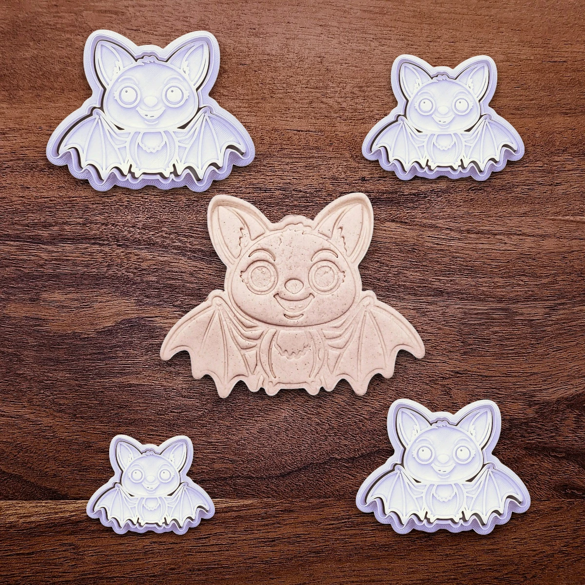 Cute bat cookie cutters with stamps alongside a dough cutout and imprint - adds cute Halloween charm, complete with cute details for whimsical baking, parties, or spooky gifting. Handmade and customizable in 30 colors.