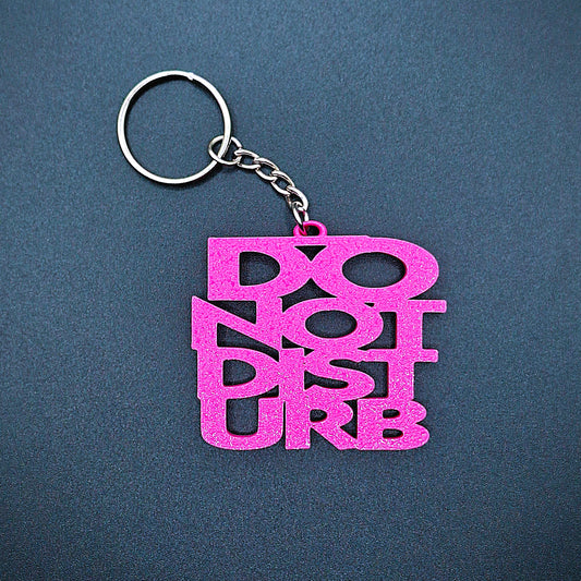 Pink Do Not Disturb keychain in bold lettering, handmade from PLA plastic, ideal for fun desk accessories or self-care boundary gifts.